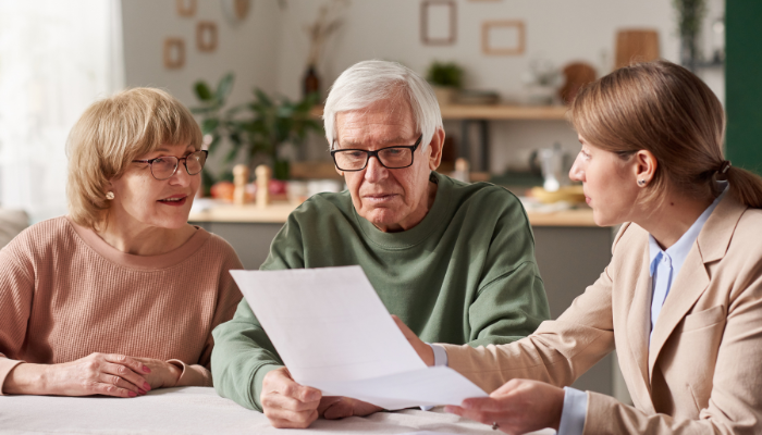Mature adult couple sitting down with a trusted legal advisor to setup a trust in order to protect their assets. 